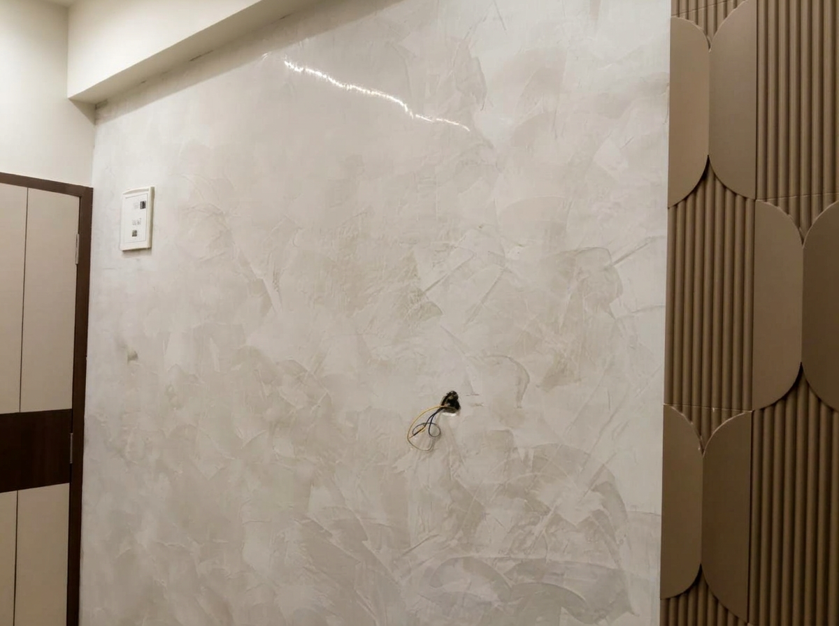 Pale textured plaster wall beside a sculptural fluted panel